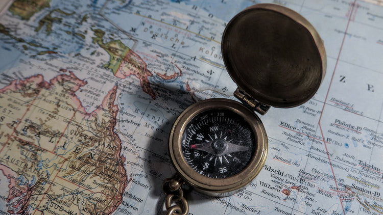 a compass with the lid open sitting on a map