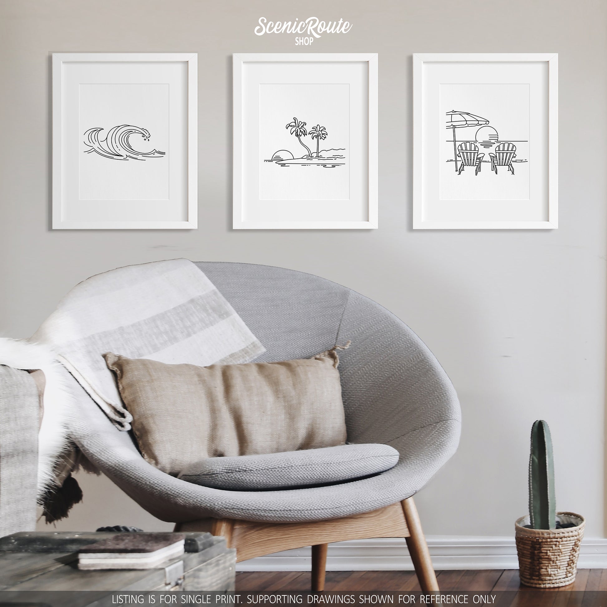 A group of three framed drawings on a white wall above a round chair. The line art drawings include Waves, an Island, and Adirondack Beach Chairs