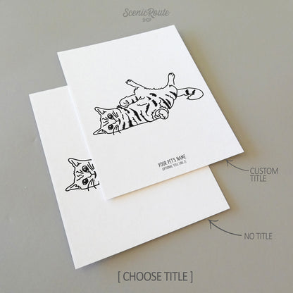 Two line art drawings of a Playful Cat on white linen paper with a gray background.  The pieces are shown with “No Title” and “Custom Title” options for the available art print options.