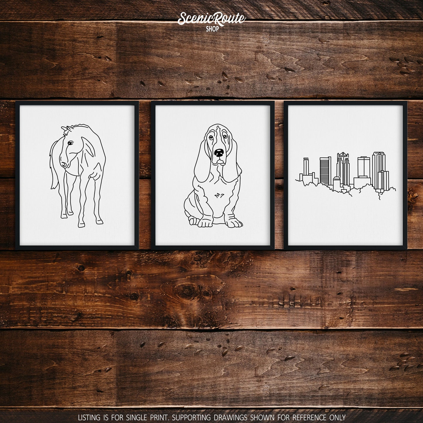 A group of three framed drawings on a dark wood wall.  The line art drawings include a horse, basset hound dog, and Birmingham Alabama skyline