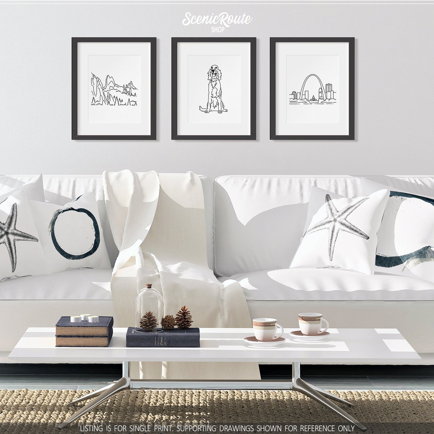 A group of three framed drawings on a white wall above a couch. The line art drawings include the Garden of the Gods, an Irish Setter dog, and the Saint Louis Skyline