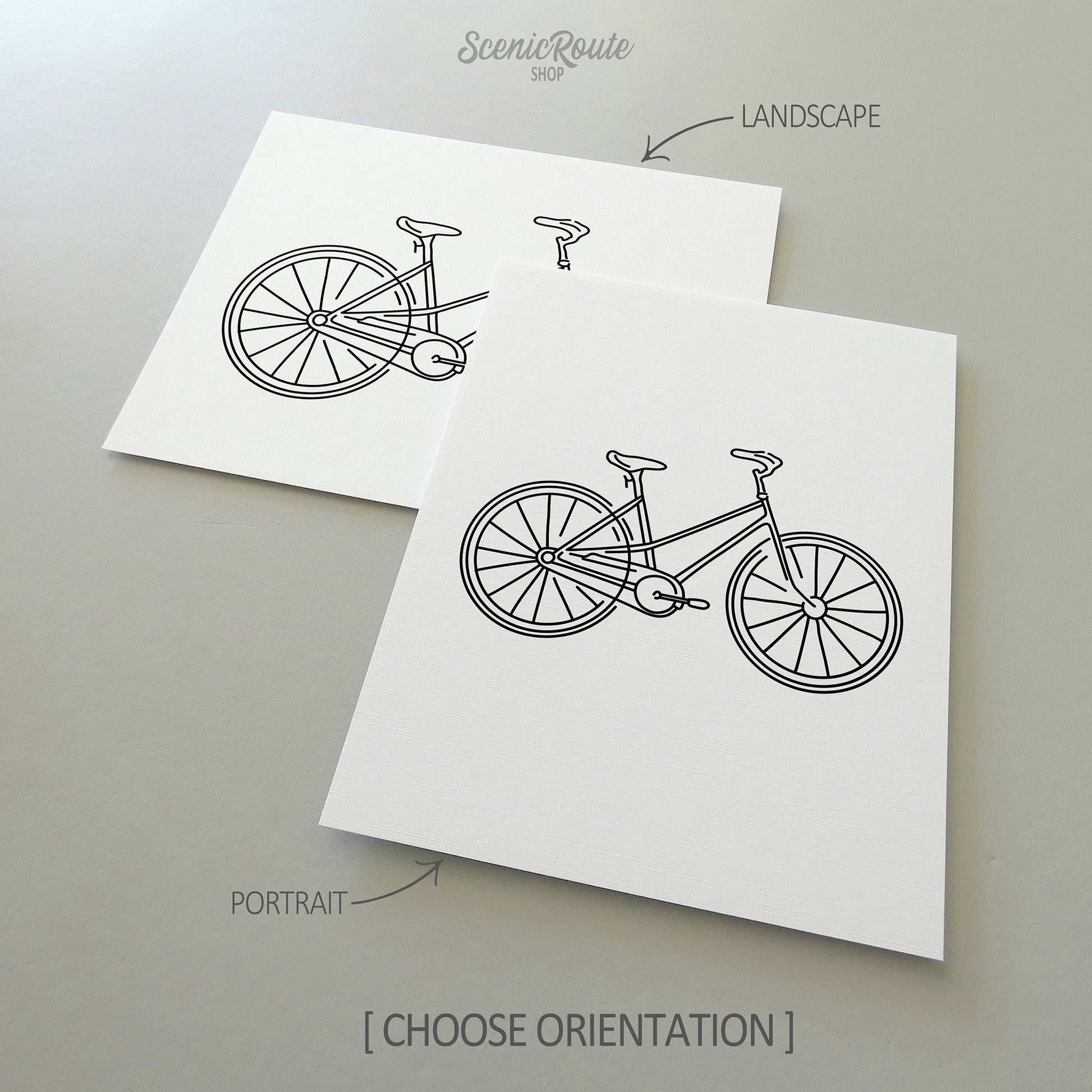 Two line art drawings of a Bicycle on white linen paper with a gray background.  The pieces are shown in portrait and landscape orientation for the available art print options.