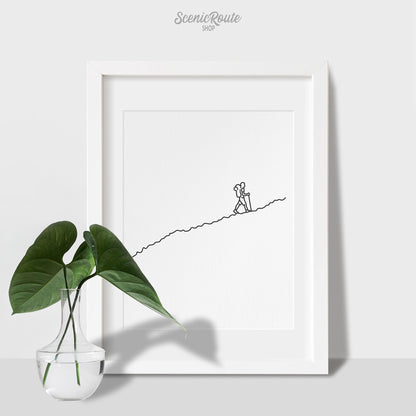 A framed line art drawing of a person Hiking with a vase