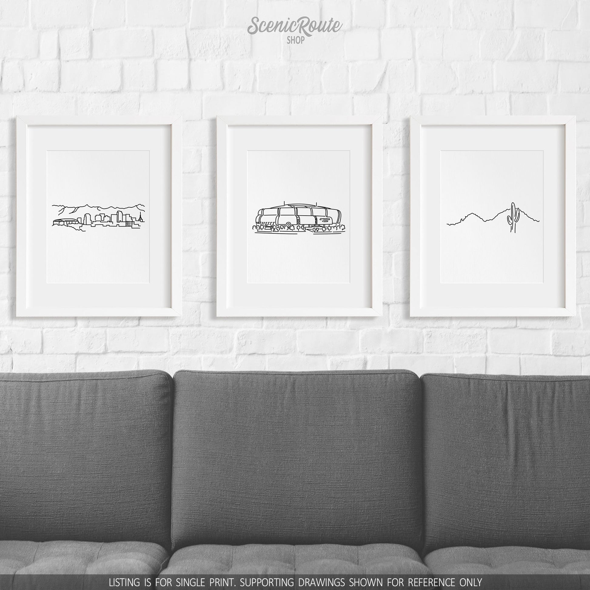 A group of three framed drawings on a wall above a couch. The line art drawings include the Phoenix Skyline, Cardinals Stadium, and Camelback Mountain