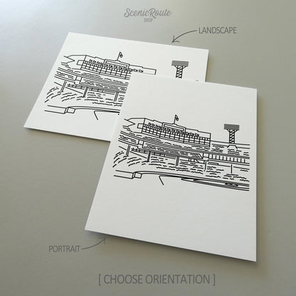 Two line art drawings of Fenway Park on white linen paper with a gray background.  The pieces are shown in portrait and landscape orientation for the available art print options.