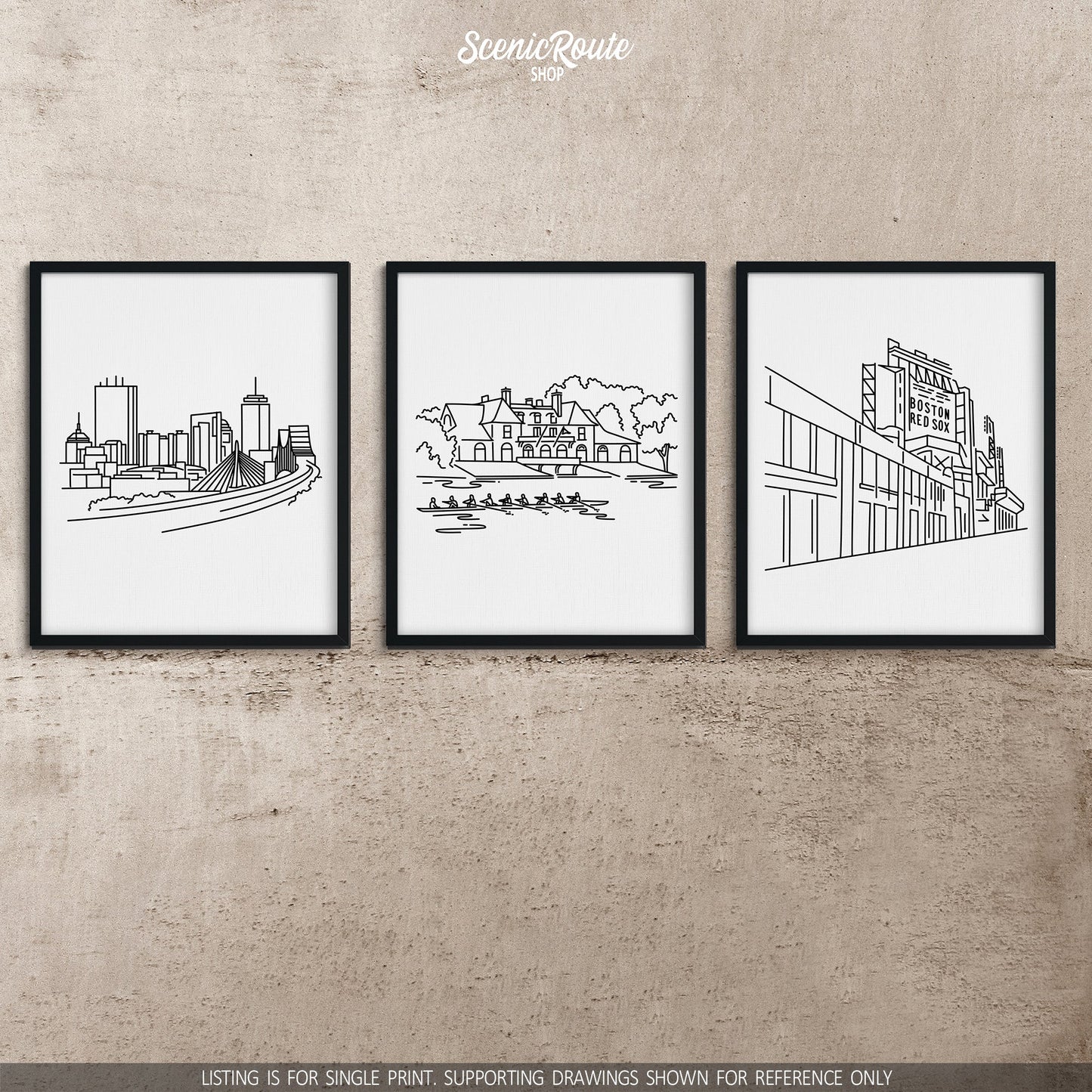 A group of three framed drawings on a concrete wall. The line art drawings include the Boston Skyline, Harvard Boathouse, and Fenway Park