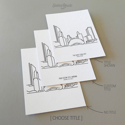 Three line art drawings of the Chicago "Bean" Cloud Gate Sculpture on white linen paper with a gray background.  The pieces are shown with title options that can be chosen and personalized.