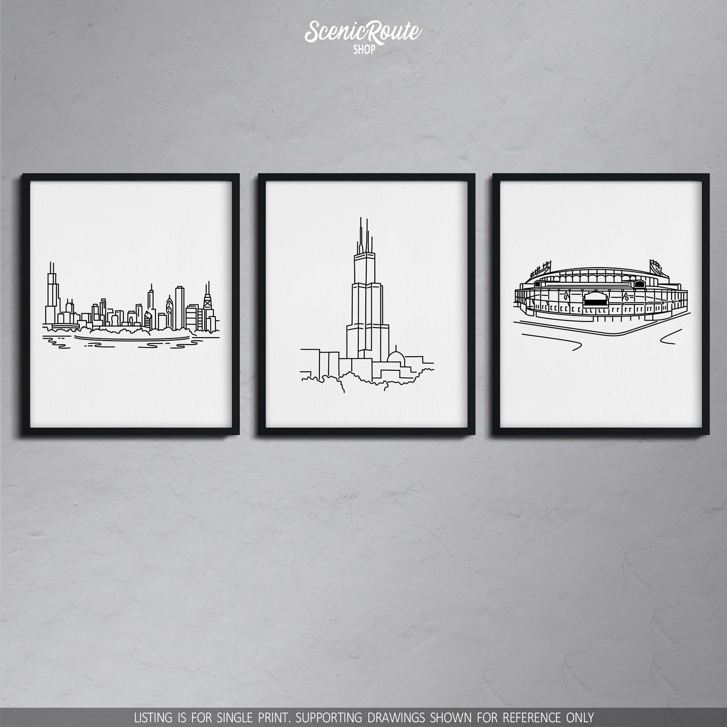 A group of three framed drawings on a gray wall. The line art drawings include the Chicago Skyline, Willis Sears Tower, and Wrigley Field