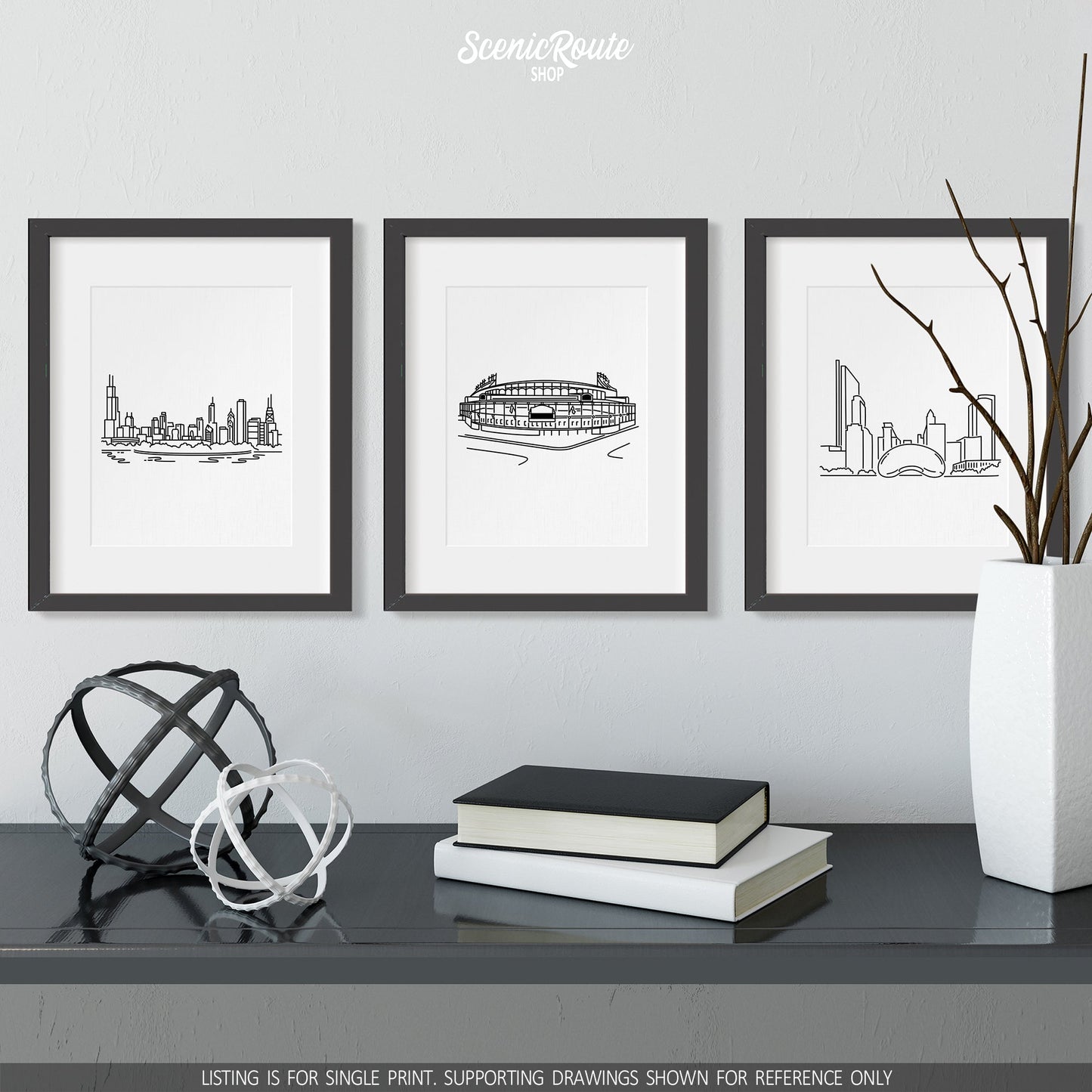 A group of three framed drawings on a wall above a dresser with books and figurines. The line art drawings include the Chicago Skyline, Wrigley Field, and the Bean Cloudgate Sculpture
