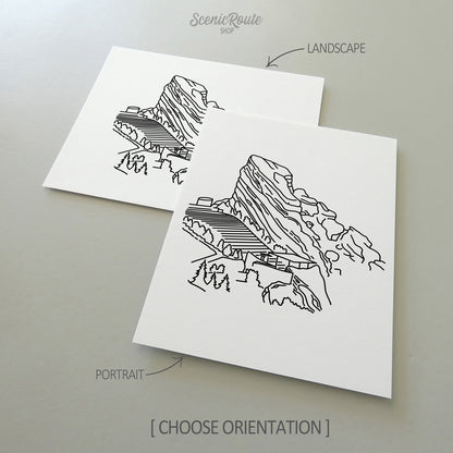 Two line art drawings of the Red Rocks Amphitheatre on white linen paper with a gray background.  The pieces are shown in portrait and landscape orientation for the available art print options.