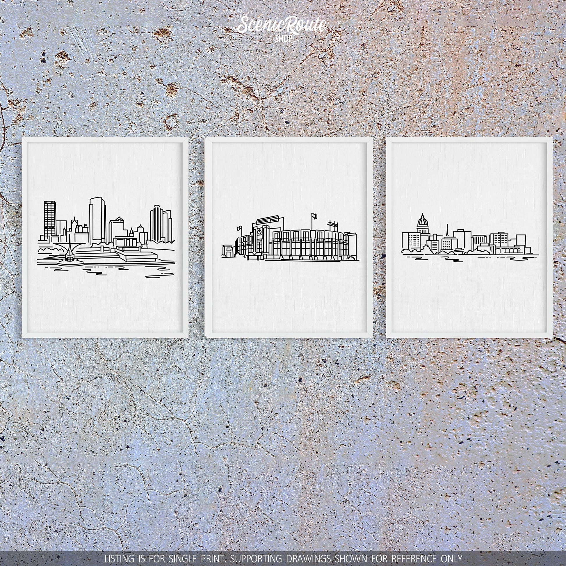 A group of three framed drawings on a concrete wall. The line art drawings include the Milwaukee Skyline, Lambeau Field, and the Madison Skyline