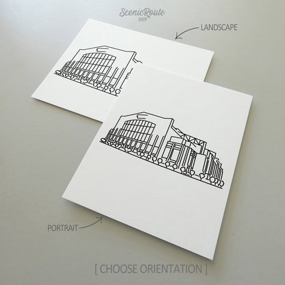 Two line art drawings of the Colts Stadium on white linen paper with a gray background.  The pieces are shown in portrait and landscape orientation for the available art print options.