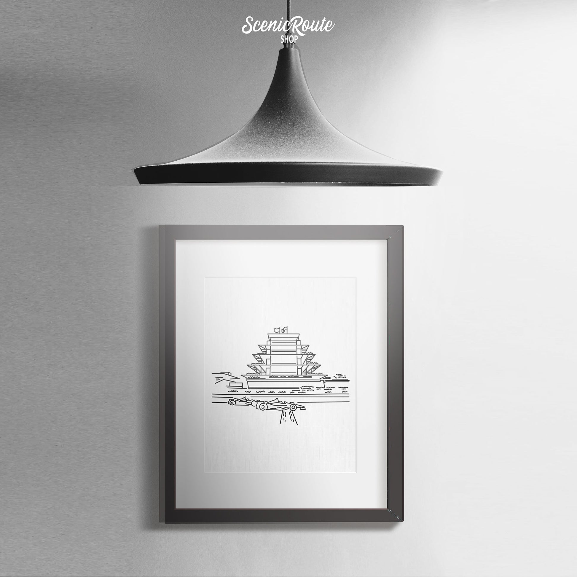 A framed line art drawing of the Speedway Pagoda with a hanging pendant light