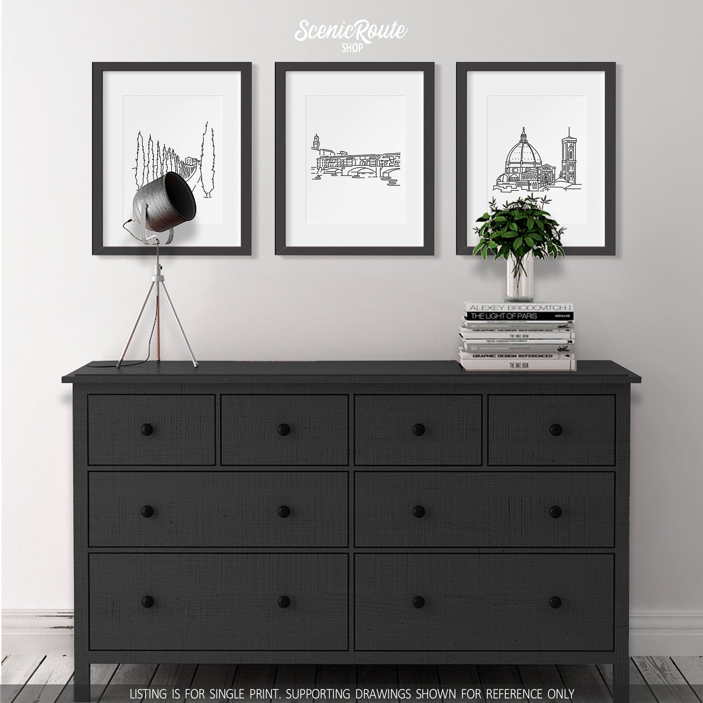 A group of three framed drawings on a wall above a dresser with books and a plant. The line art drawings include a Tuscany Drive, the Ponte Vecchio, and the Florence Duomo