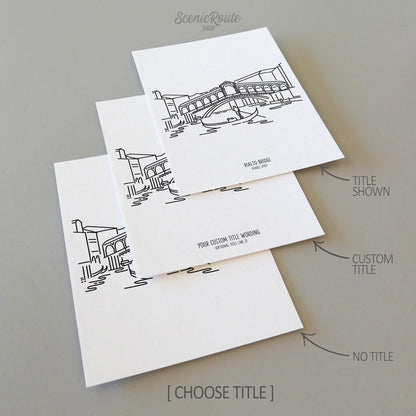 Three line art drawings of the Rialto Bridge over the Grand Canal in Venice Italy on white linen paper with a gray background.  The pieces are shown with title options that can be chosen and personalized.