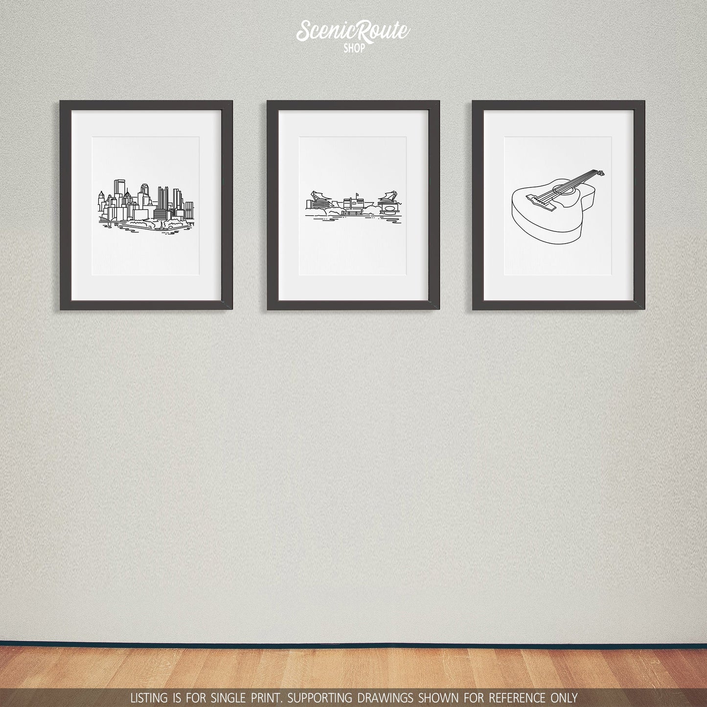 A group of three framed drawings on a white wall. The line art drawings include the Pittsburgh Skyline, Steelers Stadium, and Guitar