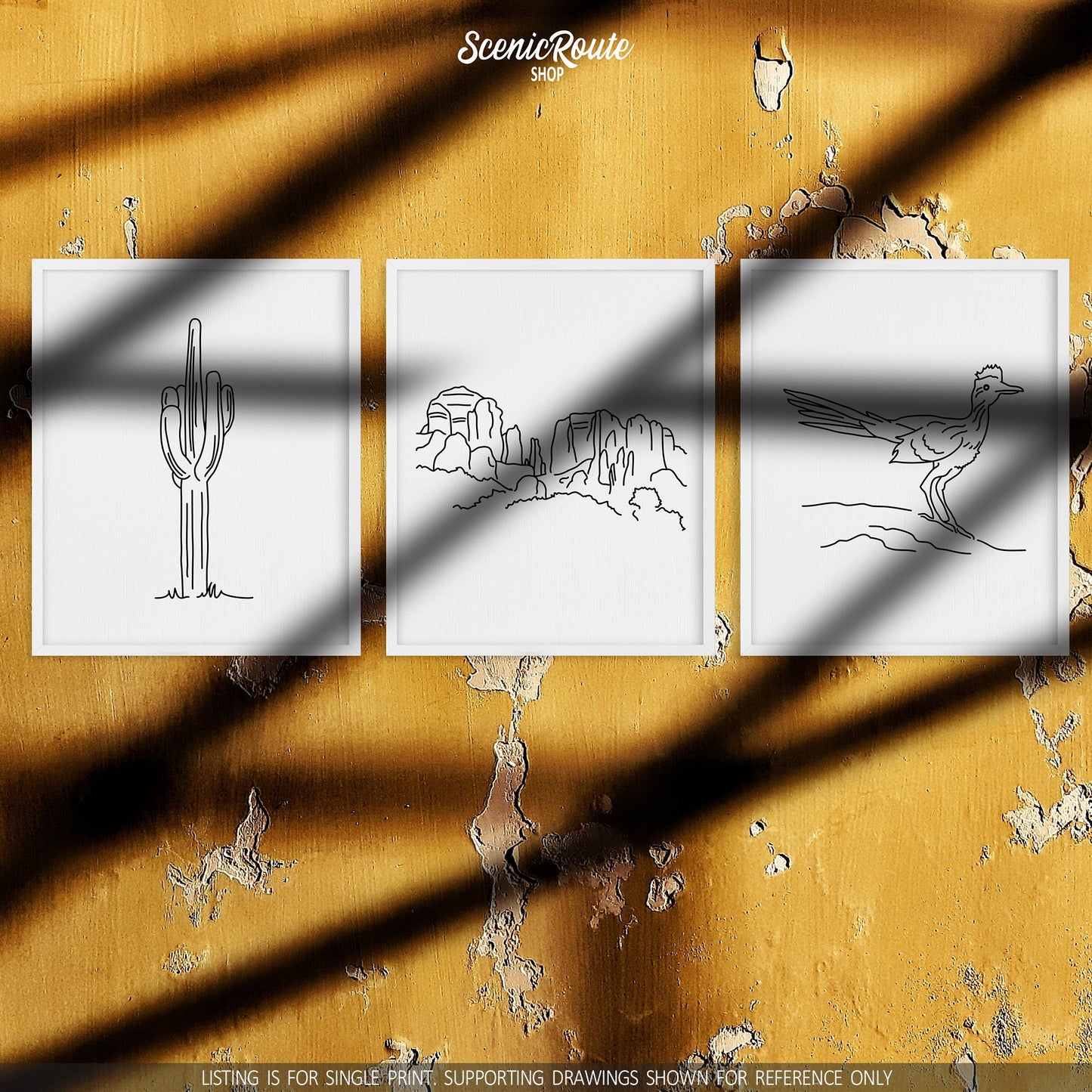 A group of three framed drawings on a yellow wall with sun shadows. The line art drawings include a Saguaro Cactus, Sedona Cathedral Rock, and a Roadrunner bird