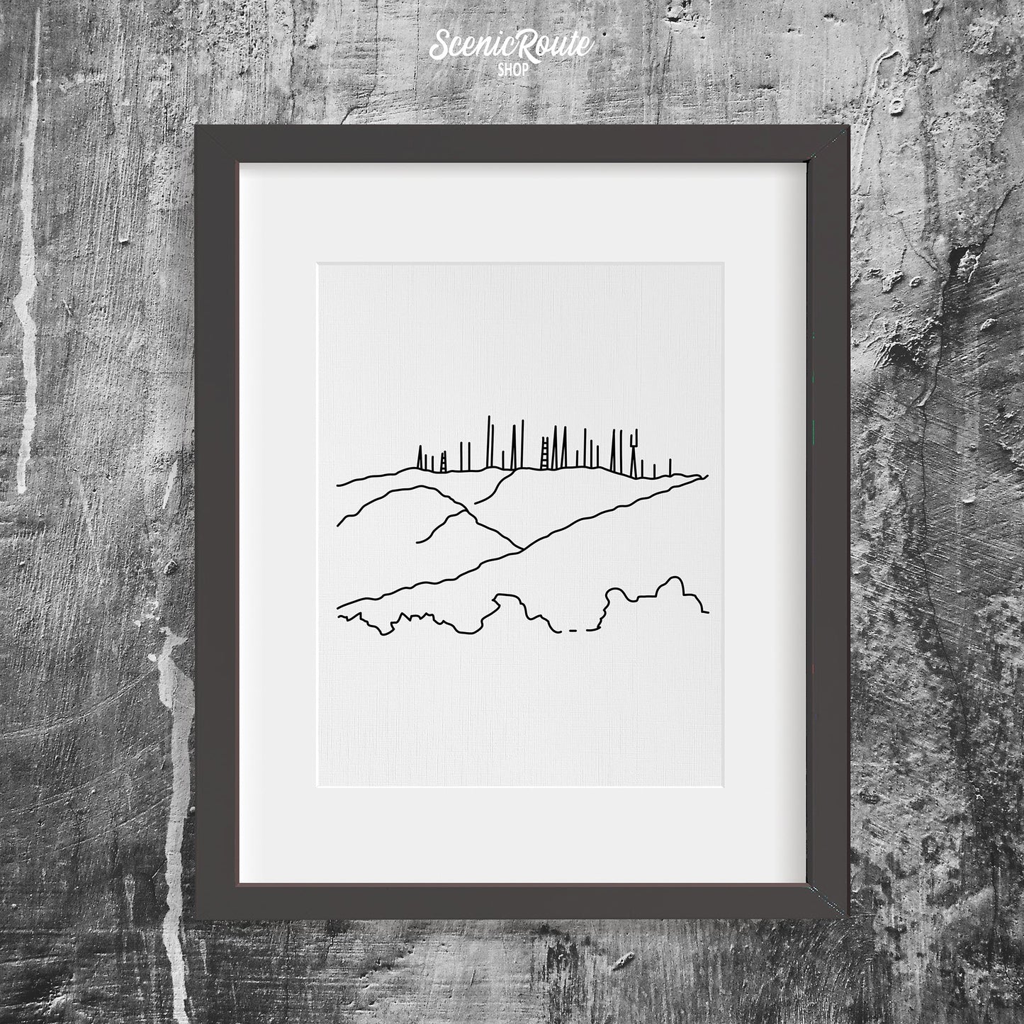 A framed line art drawing of Phoenix South Mountain on a concrete wall
