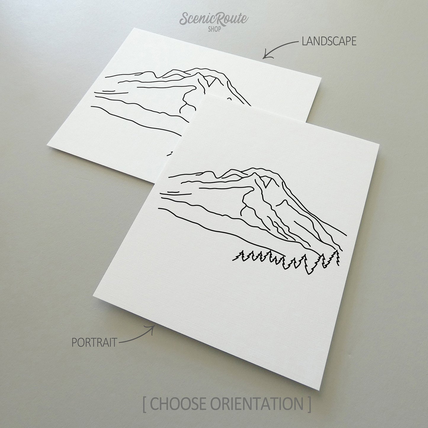Two line art drawings of Mount Hood on white linen paper with a gray background. The pieces are shown in portrait and landscape orientation for the available art print options.