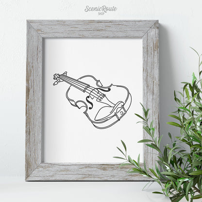A framed line art drawing of a Violin with some greenery