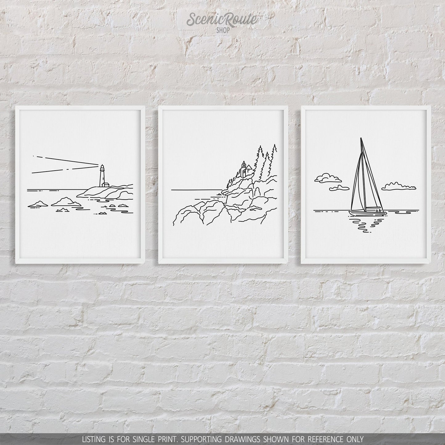 A group of three framed drawings on a brick wall. The line art drawings include a Lighthouse, Acadia National Park, and Sailing