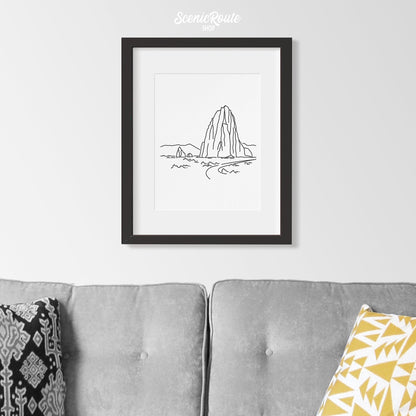 A framed line art drawing of Capitol Reef National Park above a couch