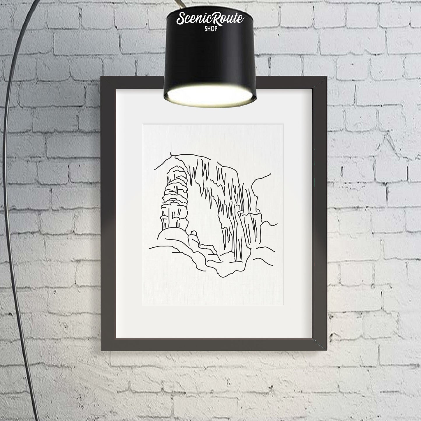 A framed line art drawing of Carlsbad Caverns National Park with a large floor lamp