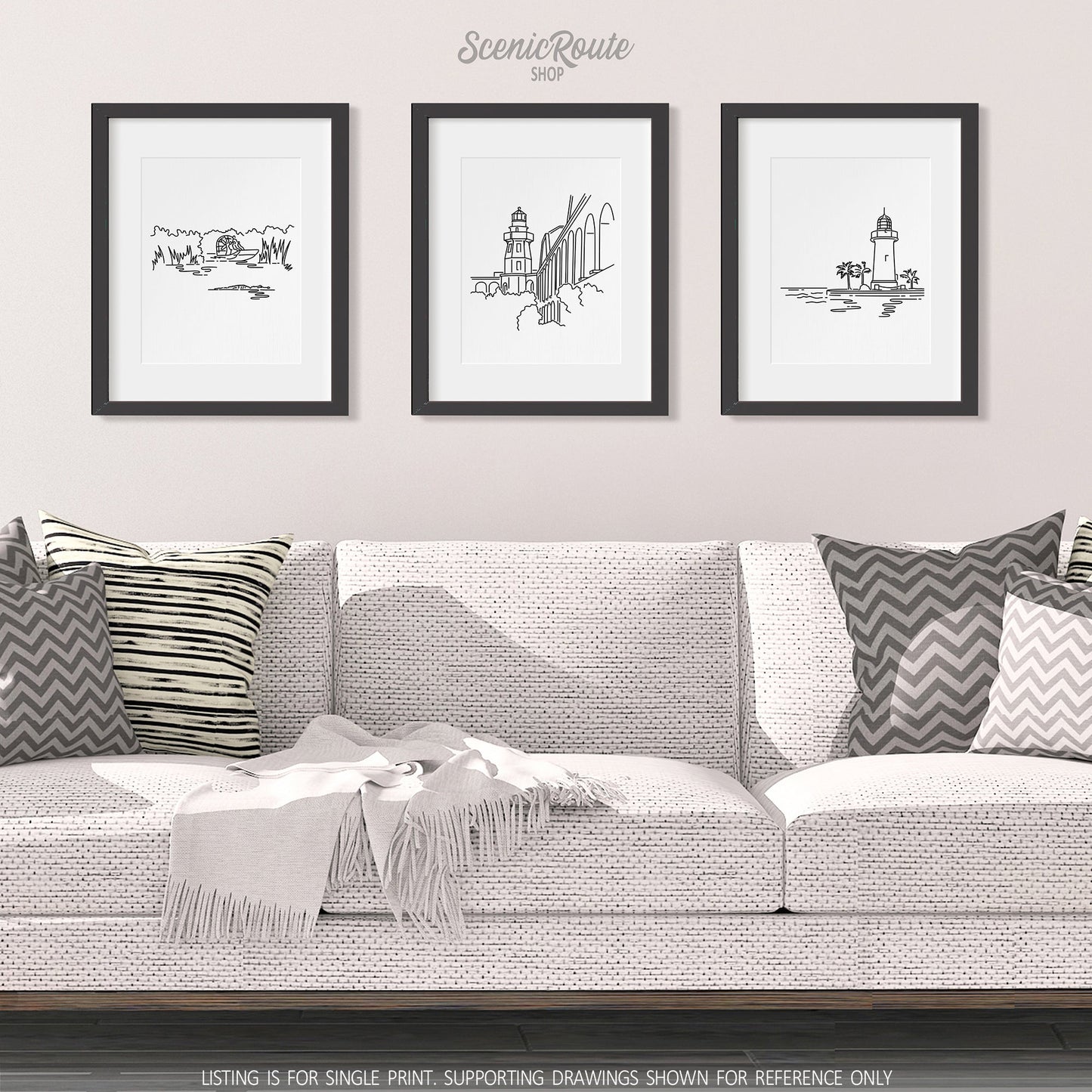 A group of three framed drawings on a white wall hanging above a couch with pillows and a blanket. The line art drawings include Everglades National Park, Dry Tortugas National Park, and Biscayne National Park