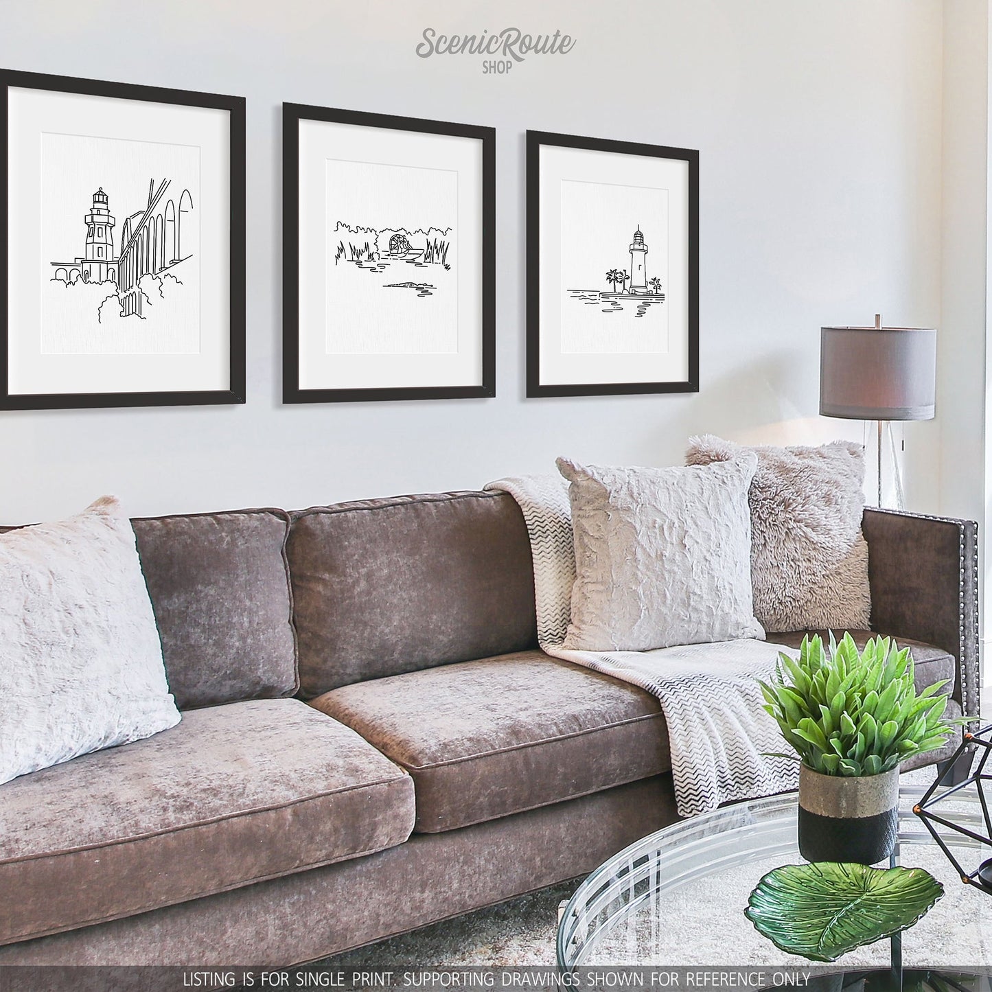 A group of three framed drawings on a white wall hanging above a couch with pillows and a blanket. The line art drawings include Dry Tortugas National Park, Everglades National Park, and Biscayne National Park