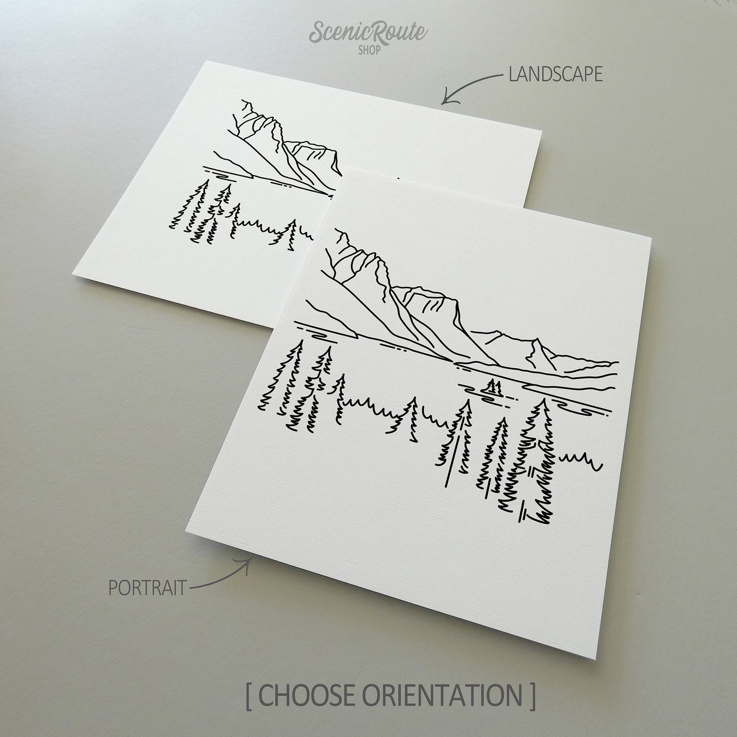 Two line art drawings of Glacier National Park on white linen paper with a gray background.  The pieces are shown in portrait and landscape orientation for the available art print options.