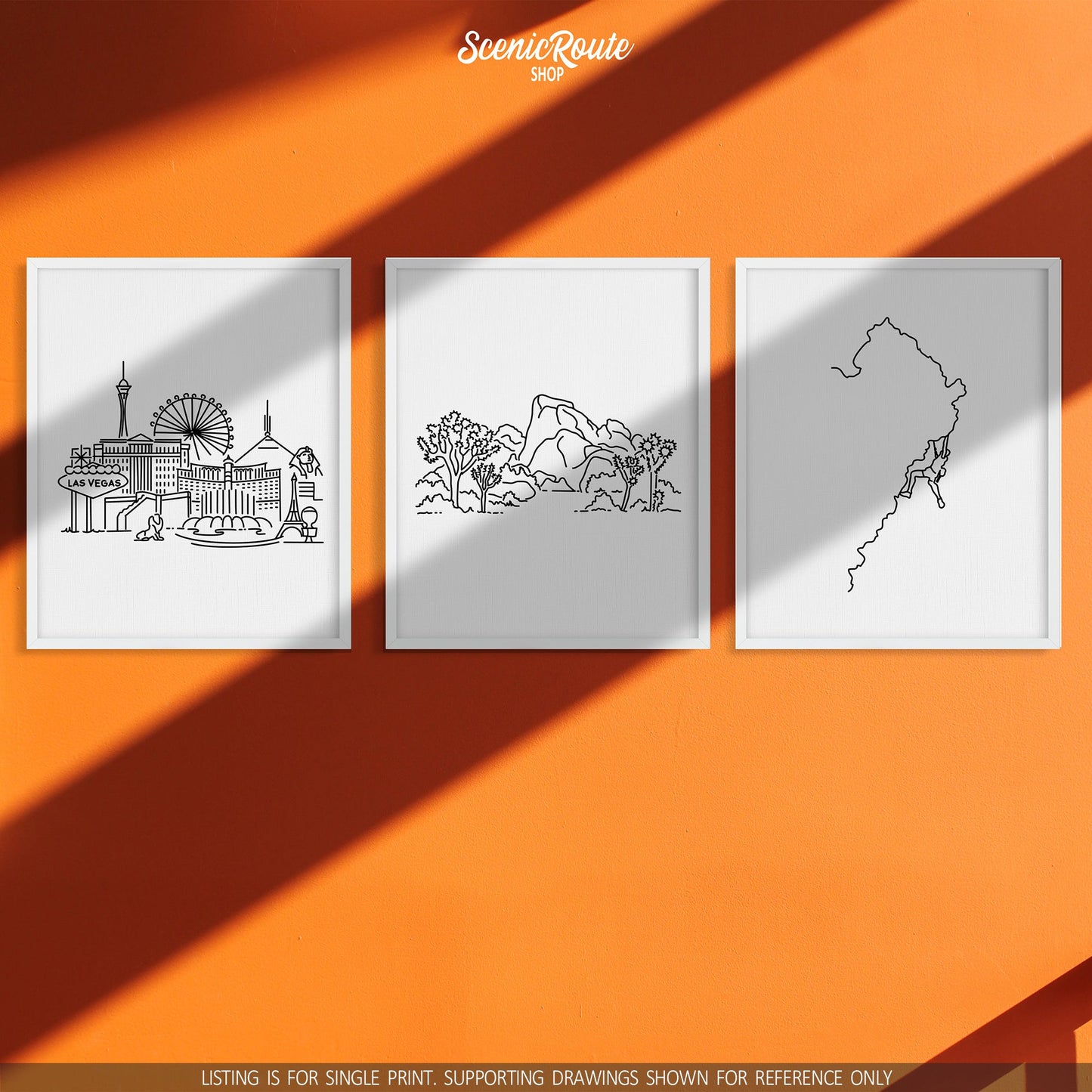 A group of three framed drawings on a orange wall. The line art drawings include the Las Vegas Skyline, Joshua Tree National Park, and Rock Climbing