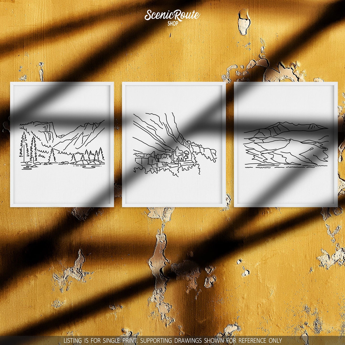 A group of three framed drawings on a yellow wall. The line art drawings include Rocky Mountain National Park, Mesa Verde National Park, and Great Sand Dunes National Park