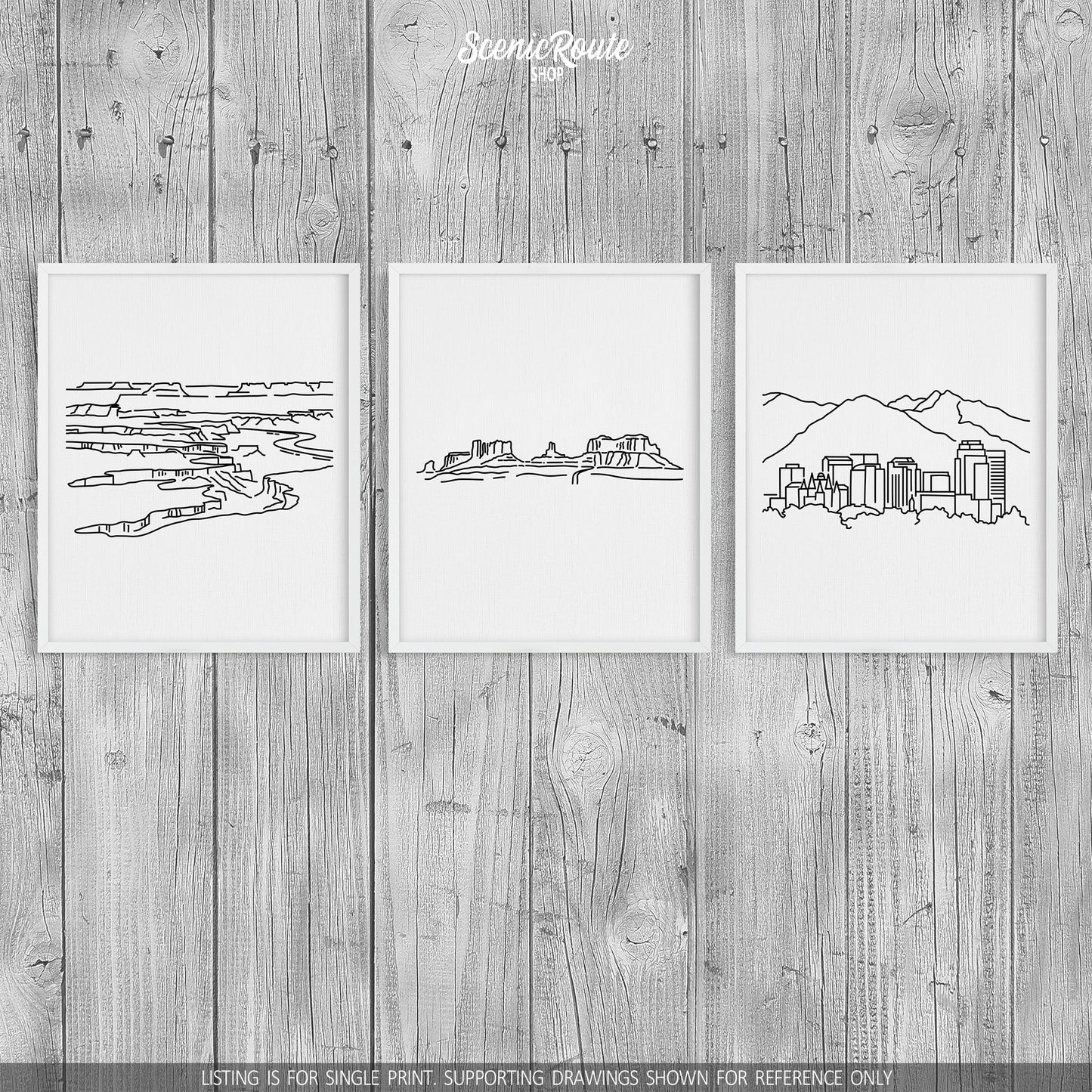 A group of three framed drawings on a wood wall. The line art drawings include Canyonlands National Park, Monument Valley, and the Salt Lake City Skyline