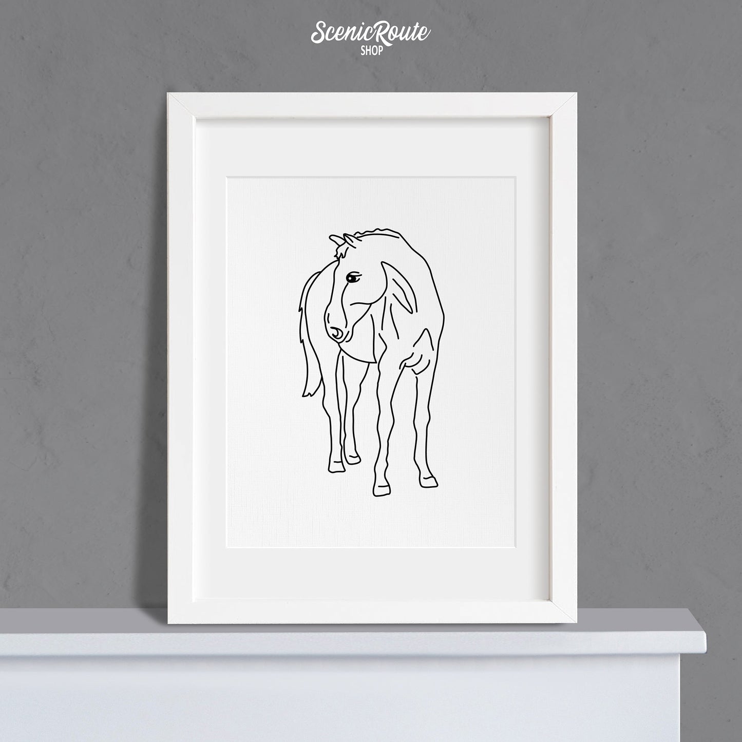 A framed line art drawing of a Horse on a mantle