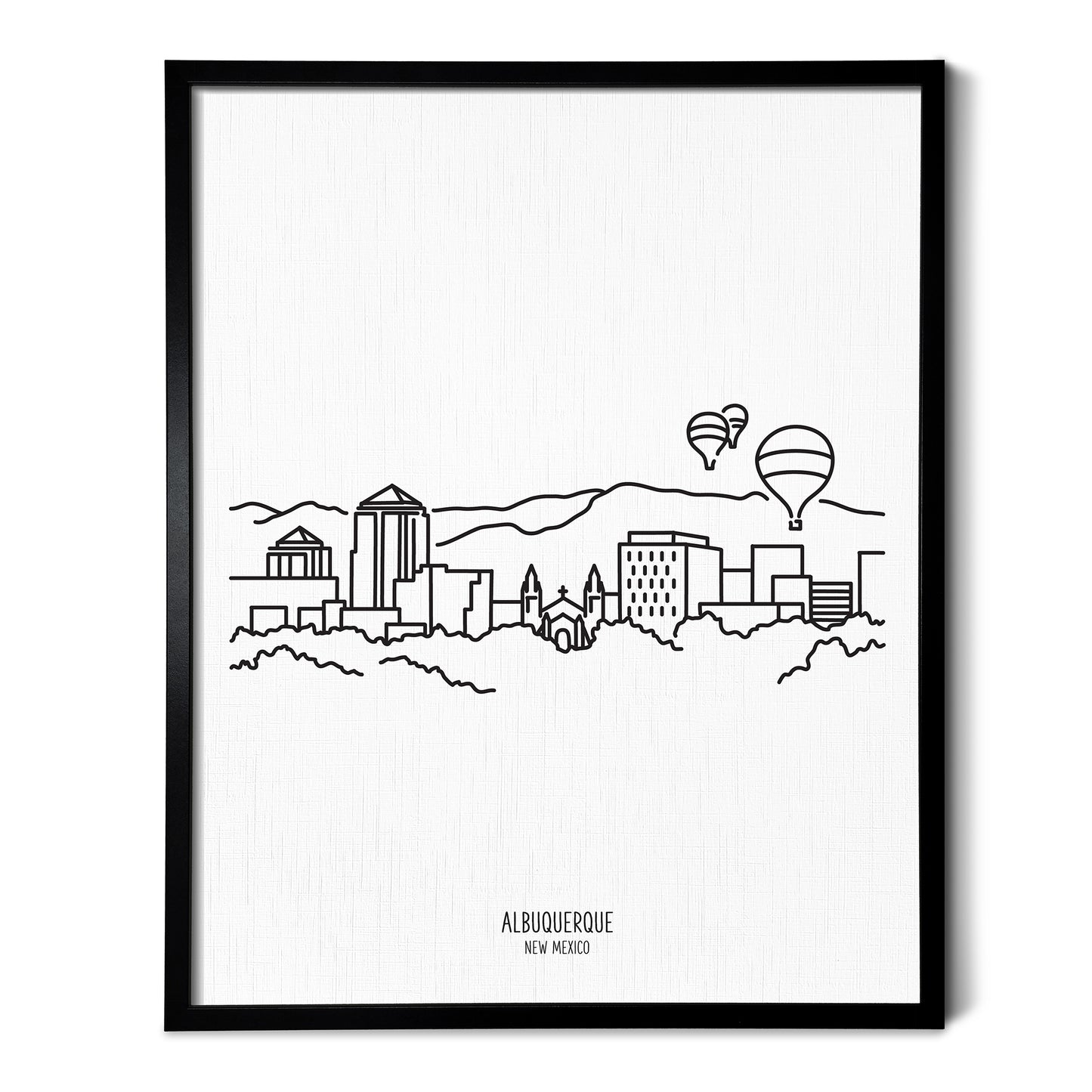 A line art drawing of the Albuquerque New Mexico Skyline on white linen paper in a thin black picture frame