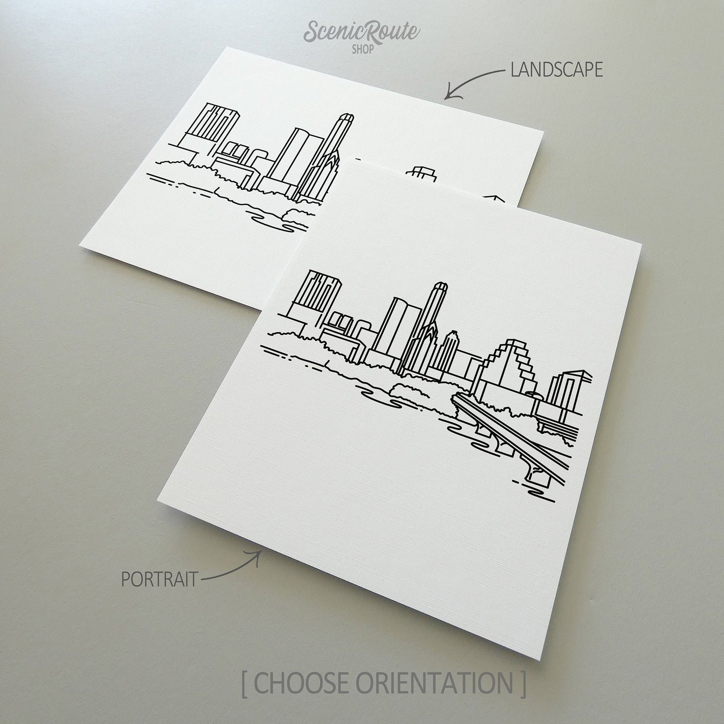 Two line art drawings of the Austin Skyline on white linen paper with a gray background.  The pieces are shown in portrait and landscape orientation for the available art print options.