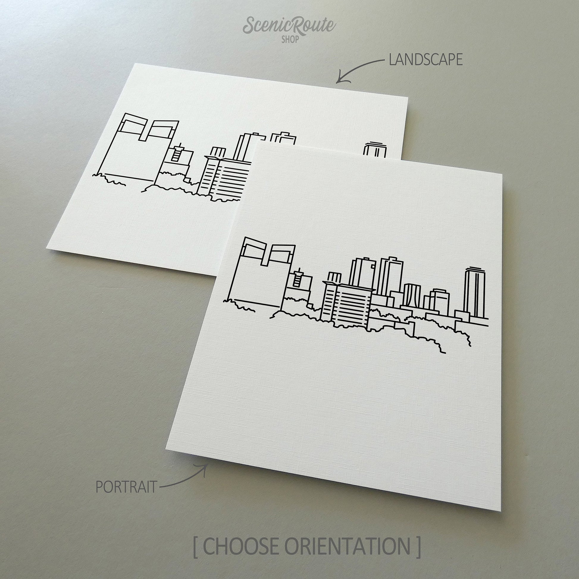 Two line art drawings of the Fort Worth Skyline on white linen paper with a gray background.  The pieces are shown in portrait and landscape orientation for the available art print options.