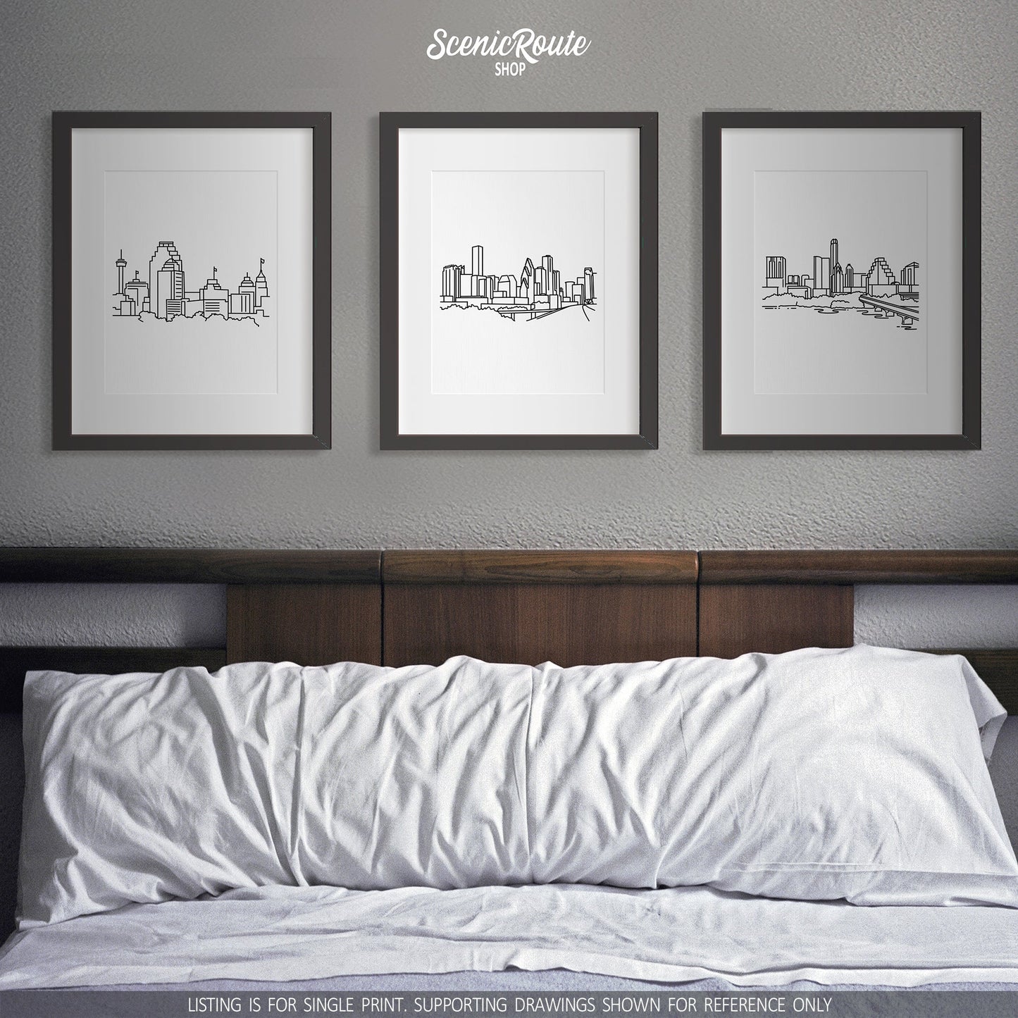 A group of three framed drawings on a white wall above a bed. The line art drawings include the San Antonio Skyline, Houston Skyline, and Austin Skyline
