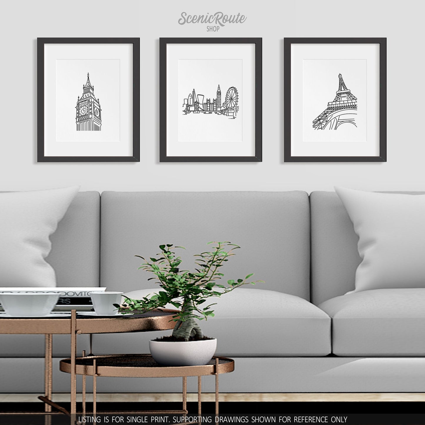 A group of three framed drawings on a wall above a couch. The line art drawings include Big Ben, London Skyline, and Eiffel Tower