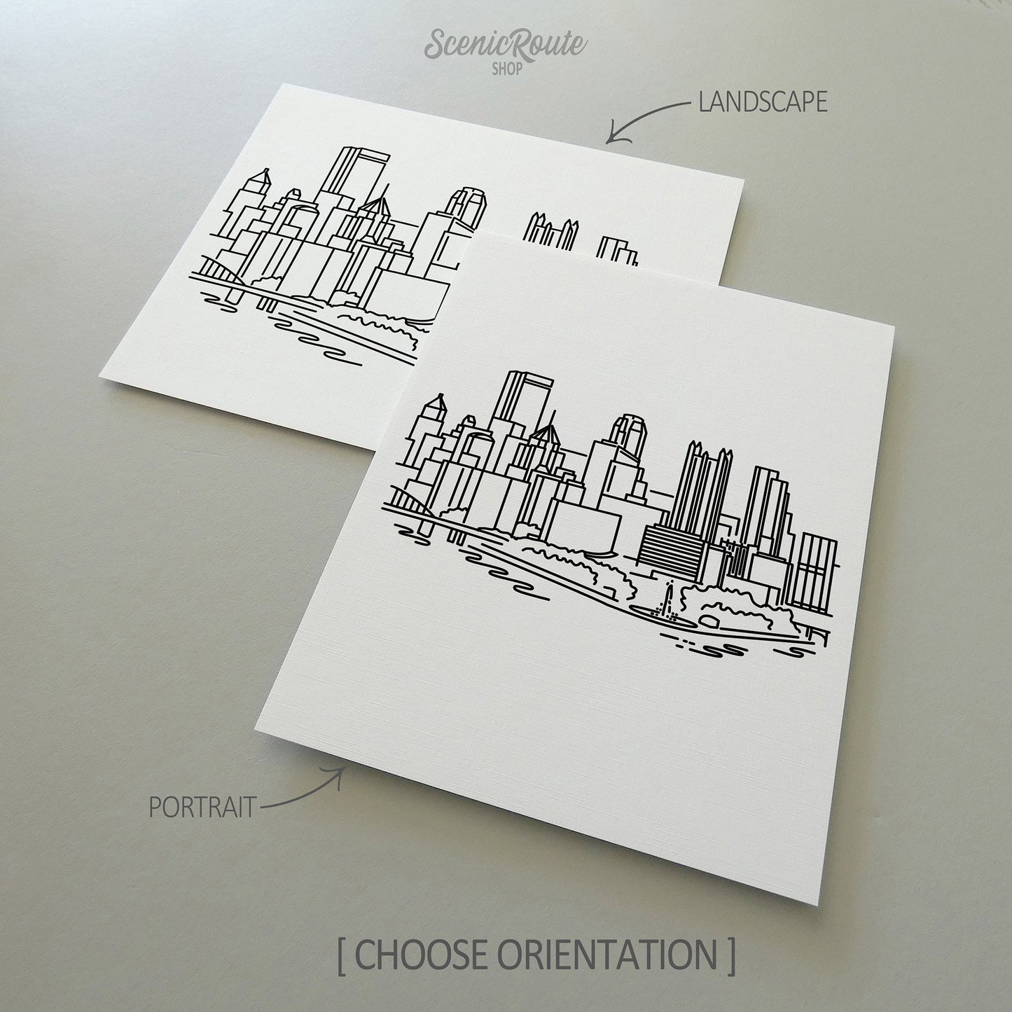 Two line art drawings of the Pittsburgh Skyline on white linen paper with a gray background. The pieces are shown in portrait and landscape orientation for the available art print options.