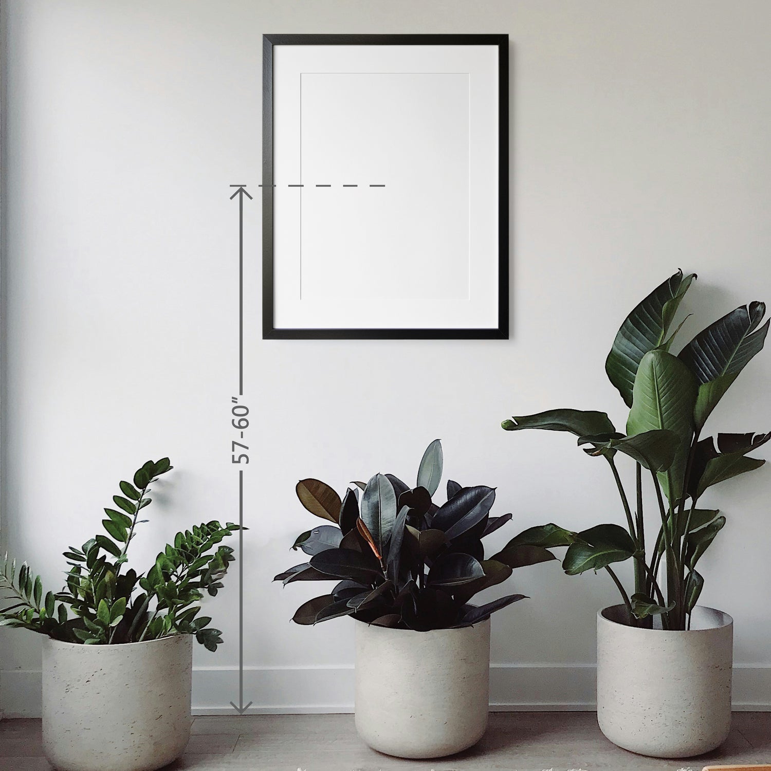 a picture frame hanging on the wall and potted plants on the floor