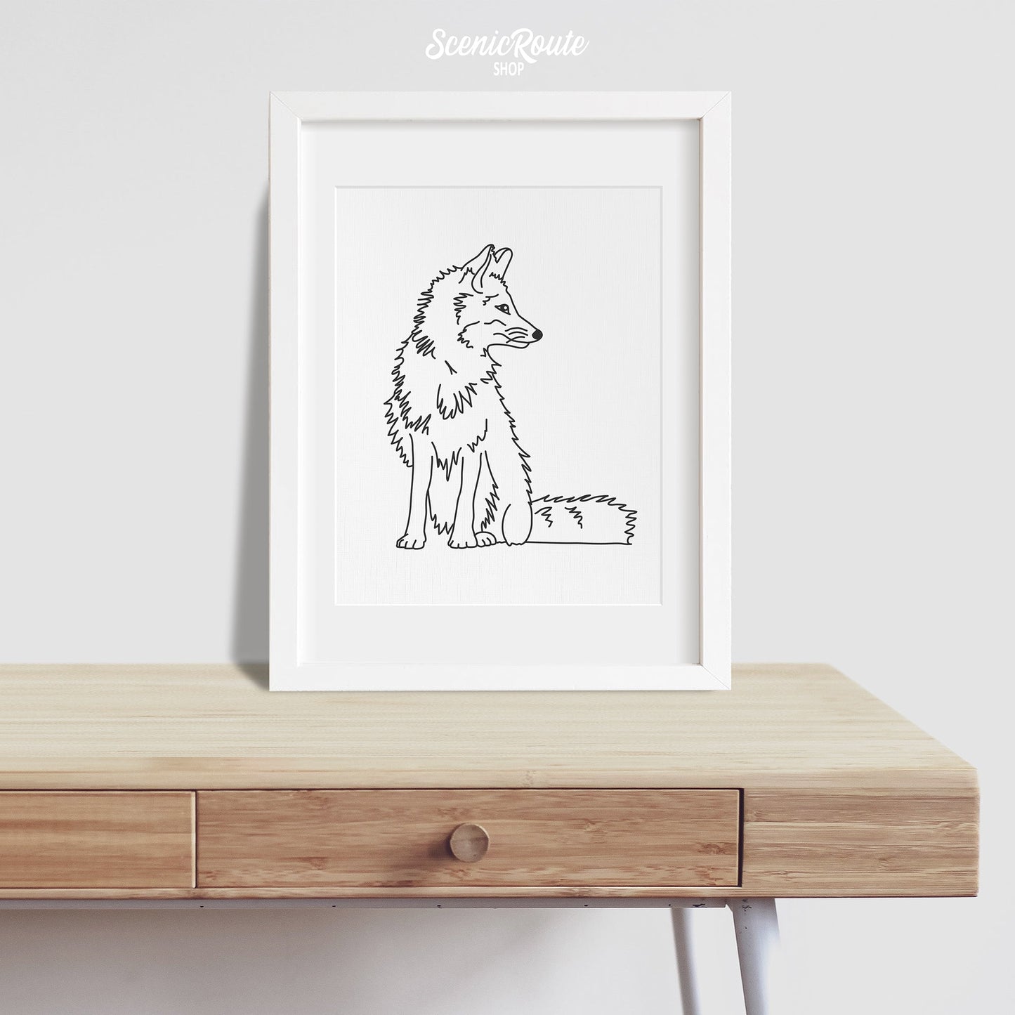 A framed line art drawing of a Fox on a desk