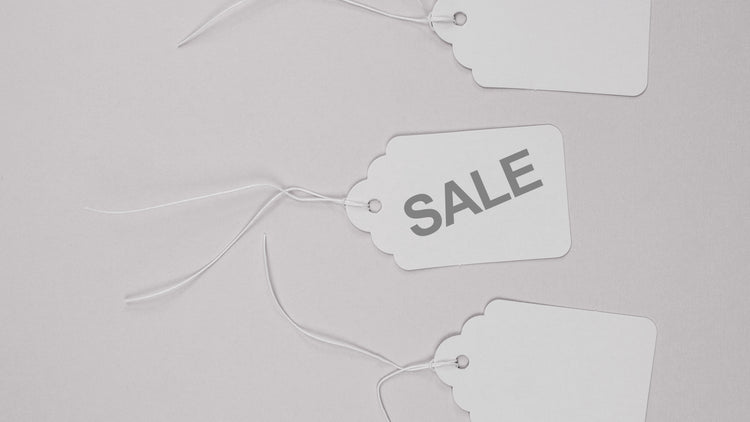 three merchandise tags with one labeled "sale"