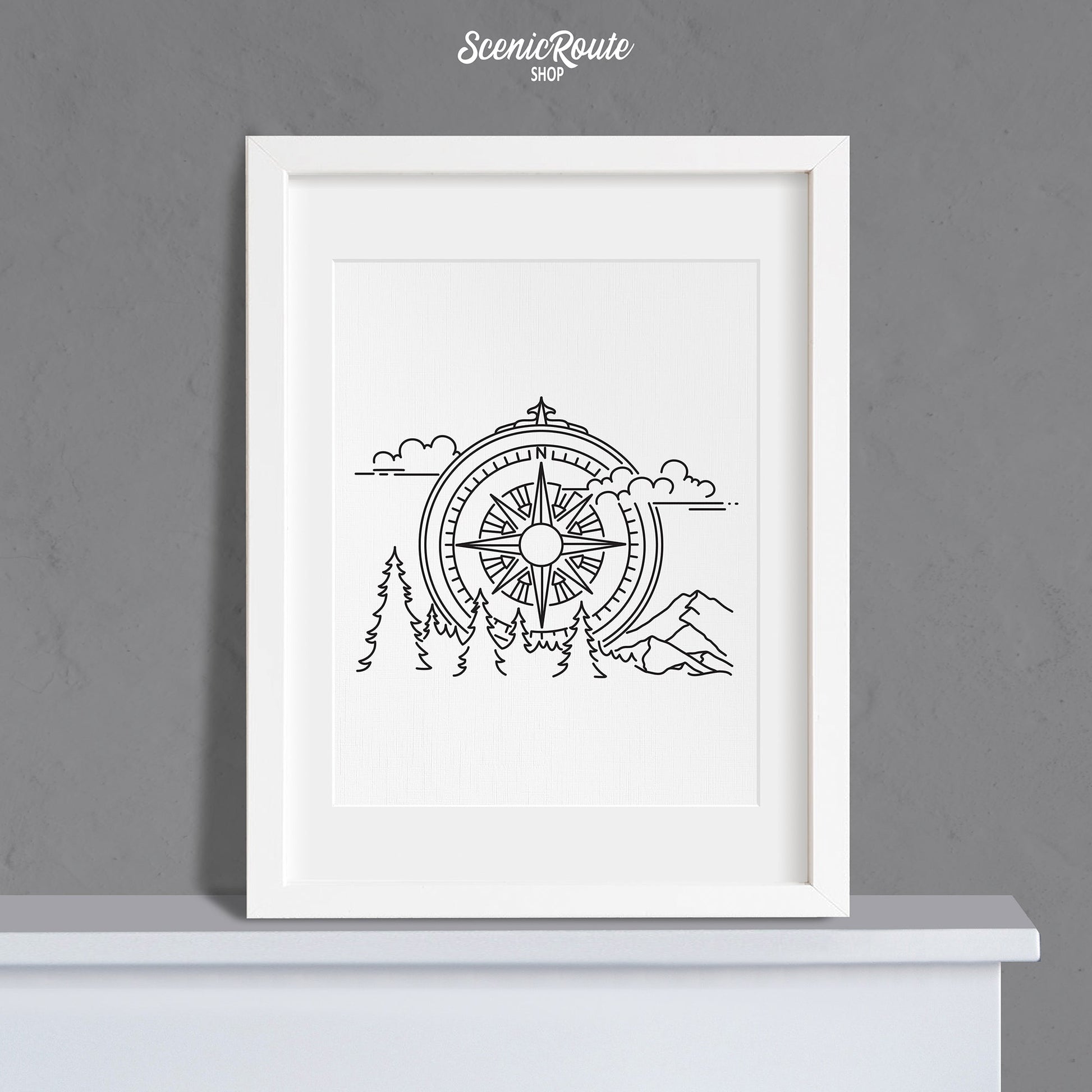 A framed line art drawing of the Adventure Compass Drawing on a mantle