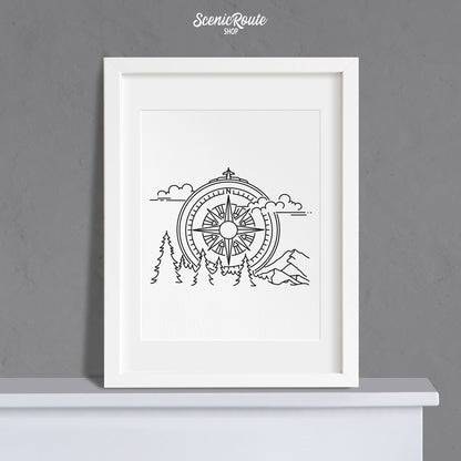 A framed line art drawing of the Adventure Compass Drawing on a mantle
