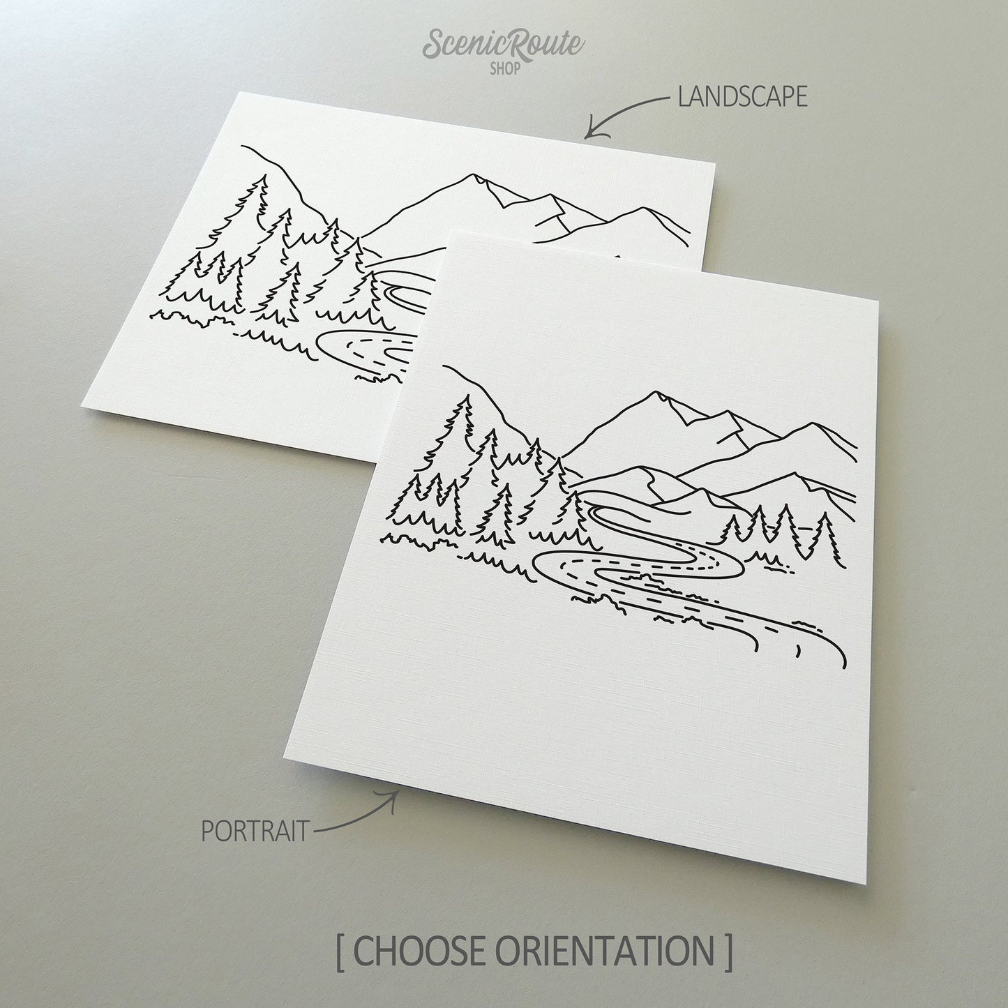 Two line art drawings of the Adventure Mountain Road Drawing on white linen paper with a gray background.  The pieces are shown in portrait and landscape orientation for the available art print options.