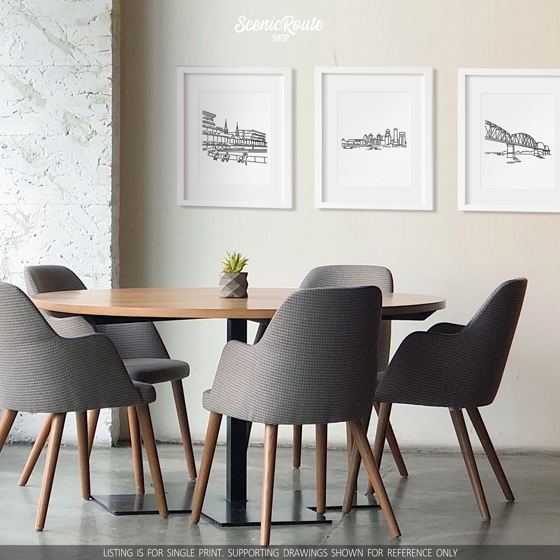 A group of three framed drawings on a white wall above a table and chairs. The line art drawings include Churchill Downs, the Louisville Skyline, and the Big Four Bridge
