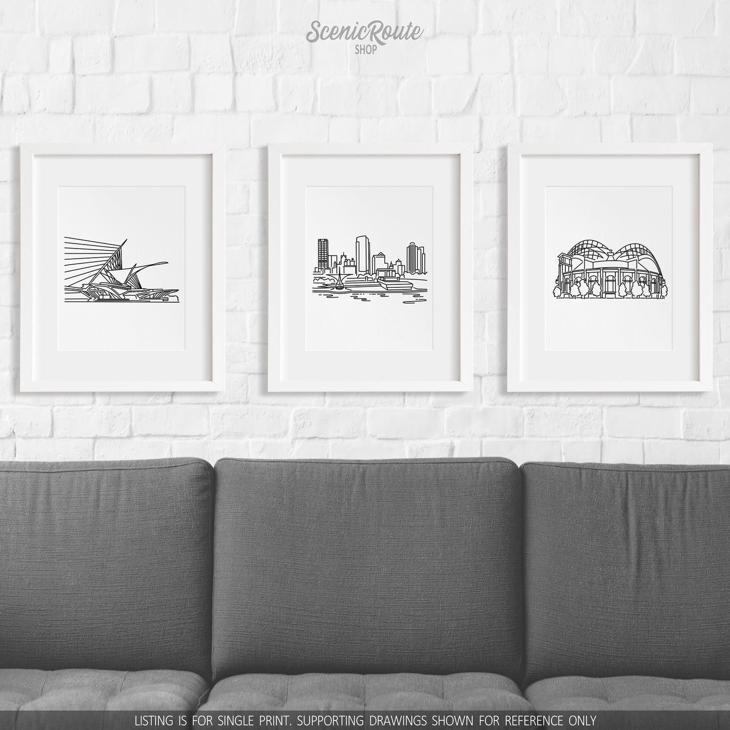 A group of three framed drawings on a wall above a couch. The line art drawings include the Milwaukee Art Museum, the Milwaukee Skyline, and Brewers Ballpark