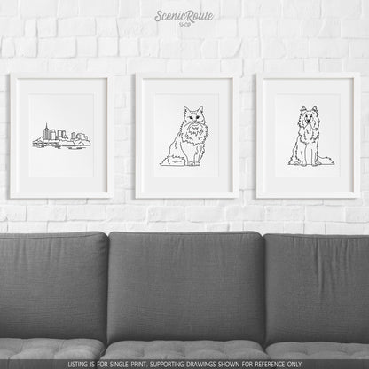 A group of three framed drawings on a wall above a couch. The line art drawings include the Tulsa Skyline, a Norwegian Forest cat, and a Shetland Sheepdog