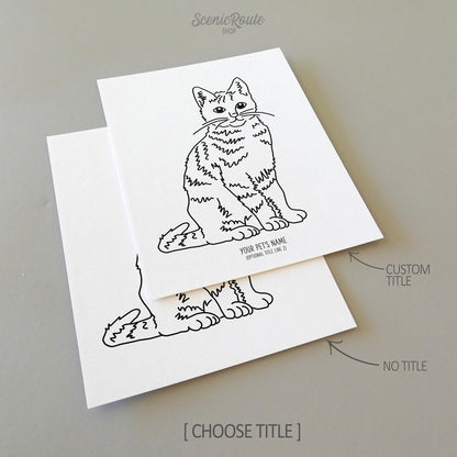 Two line art drawings of a Tabby Cat on white linen paper with a gray background.  The pieces are shown with “No Title” and “Custom Title” options for the available art print options.